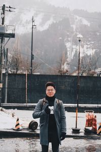 Portrait of young man standing in snow