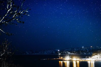 Illuminated city against sky at night