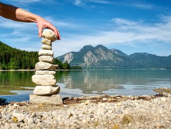 Building of stone pyramide on shore of blue water of mountain lake. mountains in water level mirror