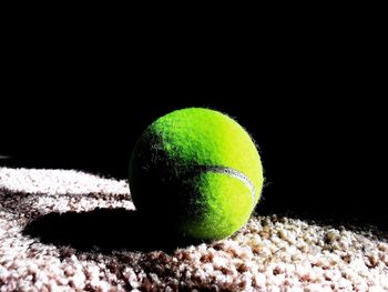 Close-up of green ball against black background