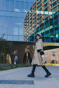 Full length of woman walking against building outdoors