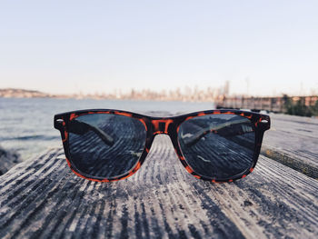 Close-up of sunglasses on beach during sunny day