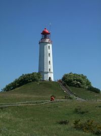 Grassy field against lighthouse