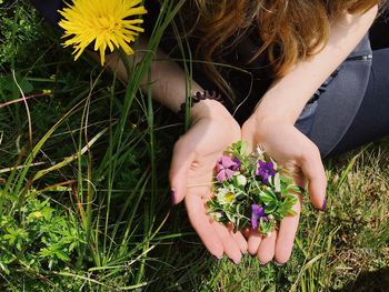 Close-up of girl with flowers on field