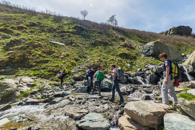 People standing on rock against sky