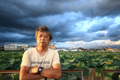 Mid adult man standing in front of agricultural field