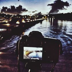 Close-up of illuminated camera against sky at night