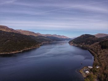 Scenic view of river amidst mountains against sky