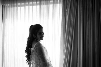 Black and white photography of side view of a young woman looking at the camera