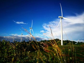 Close-up of windmill on field against sky