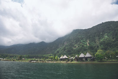 Scenic view of building by mountains against sky