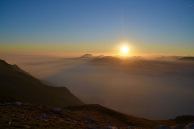 Scenic view of mountains against clear sky during sunset