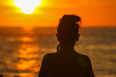 Close-up of silhouette man against orange sunset sky