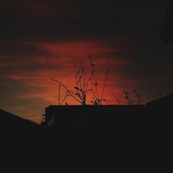 Low angle view of silhouette building against dramatic sky