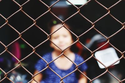 Girl seen through chainlink fence