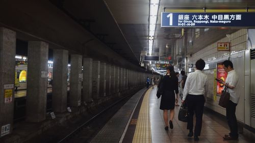 People walking on illuminated subway station