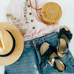 Women's fashion summer clothes. stylish female straw hat, denim short, top, black sandals.