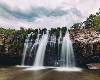 Scenic view of waterfall against sky