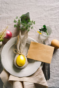 Happy easter. stylish easter eggs on a napkin with spring flowers on white wooden background