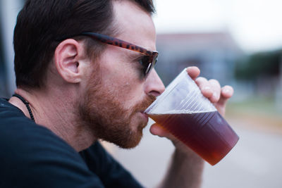 Close up portrait of bearded man drinking beer