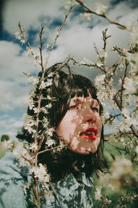 Portrait of woman with pink flowers against blurred background