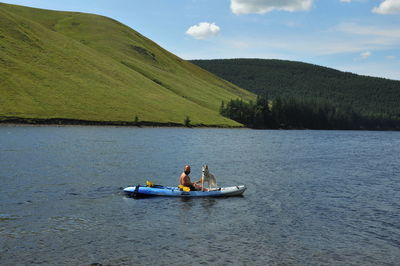 Man with dog in kayak on river