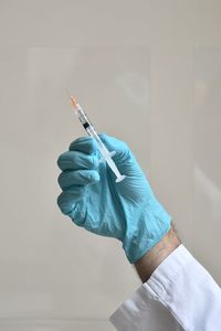 Cropped hand of doctor holding syringe