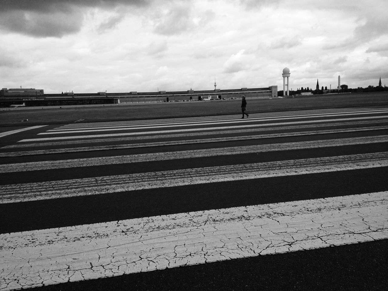 sky, road marking, cloud - sky, cloudy, transportation, road, built structure, cloud, the way forward, architecture, street, day, railing, outdoors, asphalt, text, western script, diminishing perspective, empty, building exterior