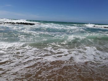 Scenic view of beach against clear blue sky