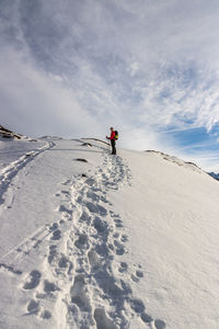 Full length of hiker standing on snow covered mountain