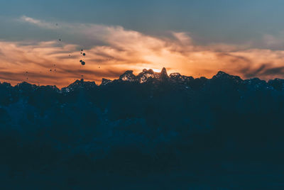 Scenic view of silhouette mountains against sky at sunset