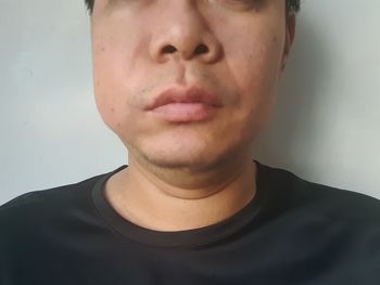 Close-up portrait of young man against gray background