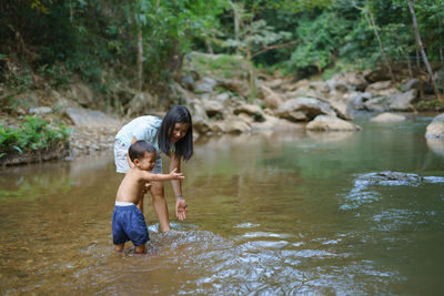 Rear view of two girls in river