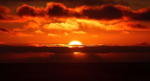 Scenic view of sea against orange sky