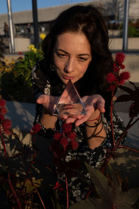 Woman holding crystal by plants