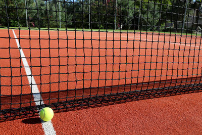 Close-up of tennis ball and net on court