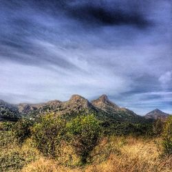 Scenic view of mountains against cloudy sky