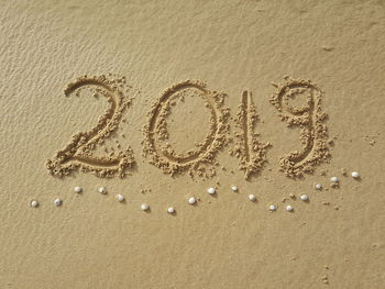 High angle view of text on sand at beach