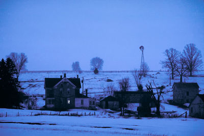 Snow covered houses against clear blue sky
