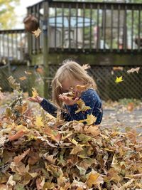 Close-up of girl with leaves during autumn