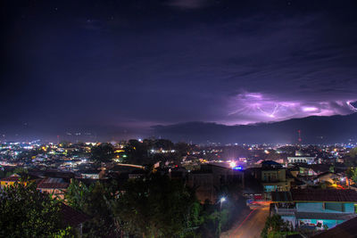 High angle view of illuminated cityscape against sky at night