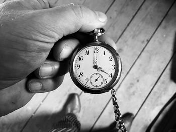 Close-up of hand holding clock