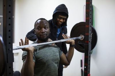 Male athlete picking up barbell while exercising in gym