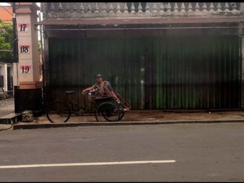 Side view of a man riding bicycle on road