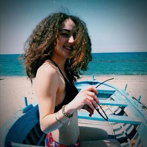 Portrait of smiling woman in boat at beach