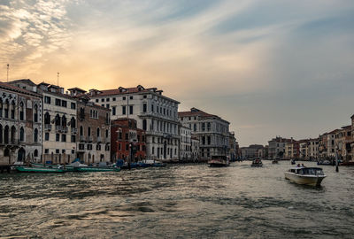 View of buildings at waterfront against cloudy sky