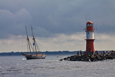 Lighthouse on sea against sky