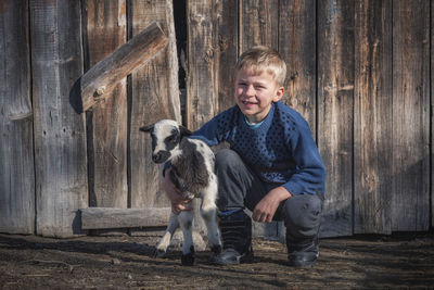 Portrait of boy standing on wood