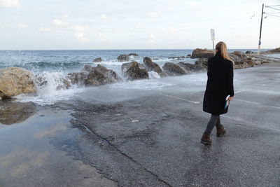 Rear view of woman walking on beach