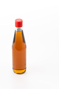 Close-up of orange bottle against white background